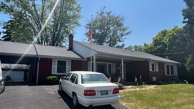 Storm damage repair is needed. A tree has fallen on the roof of a home.