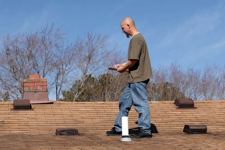 Roofing technician performing a roof inspection to determine if roof repair is needed.