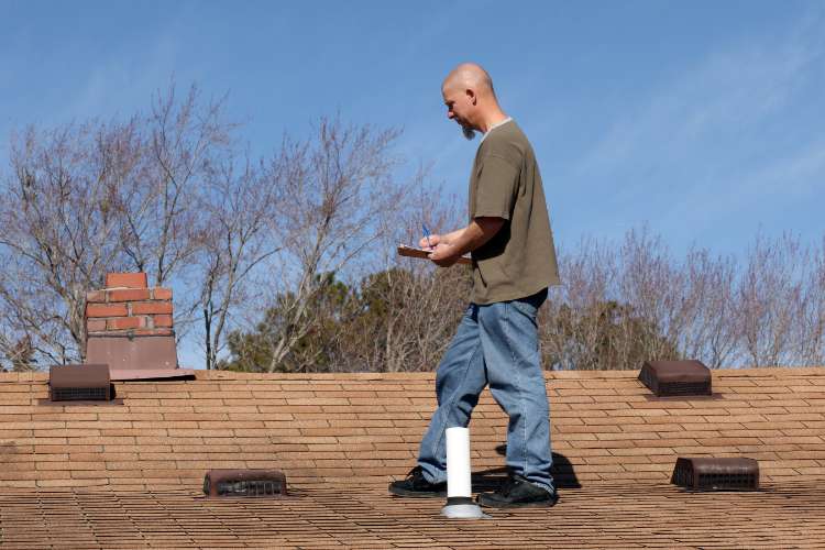 Roof repair inspection Roofing technician performing a roof inspection to determine if roof repair is needed.