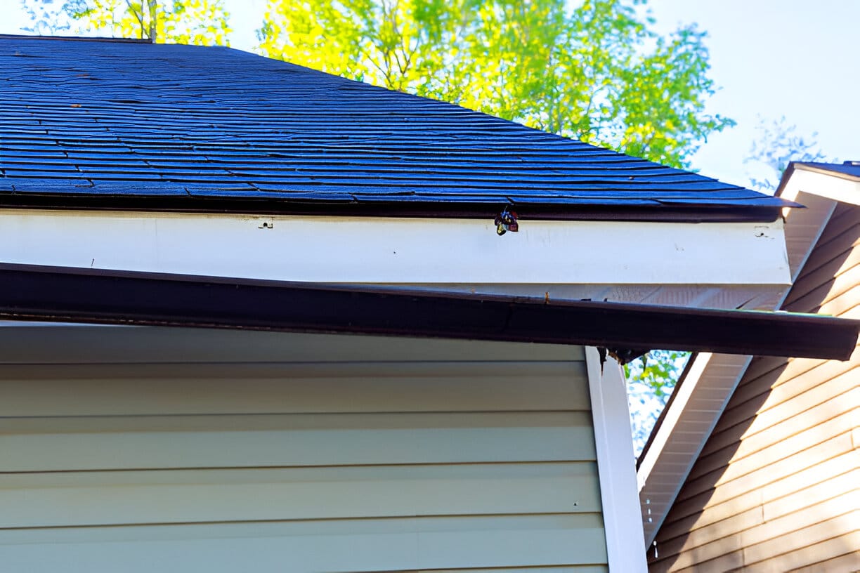 Broken rain gutter on roof of house