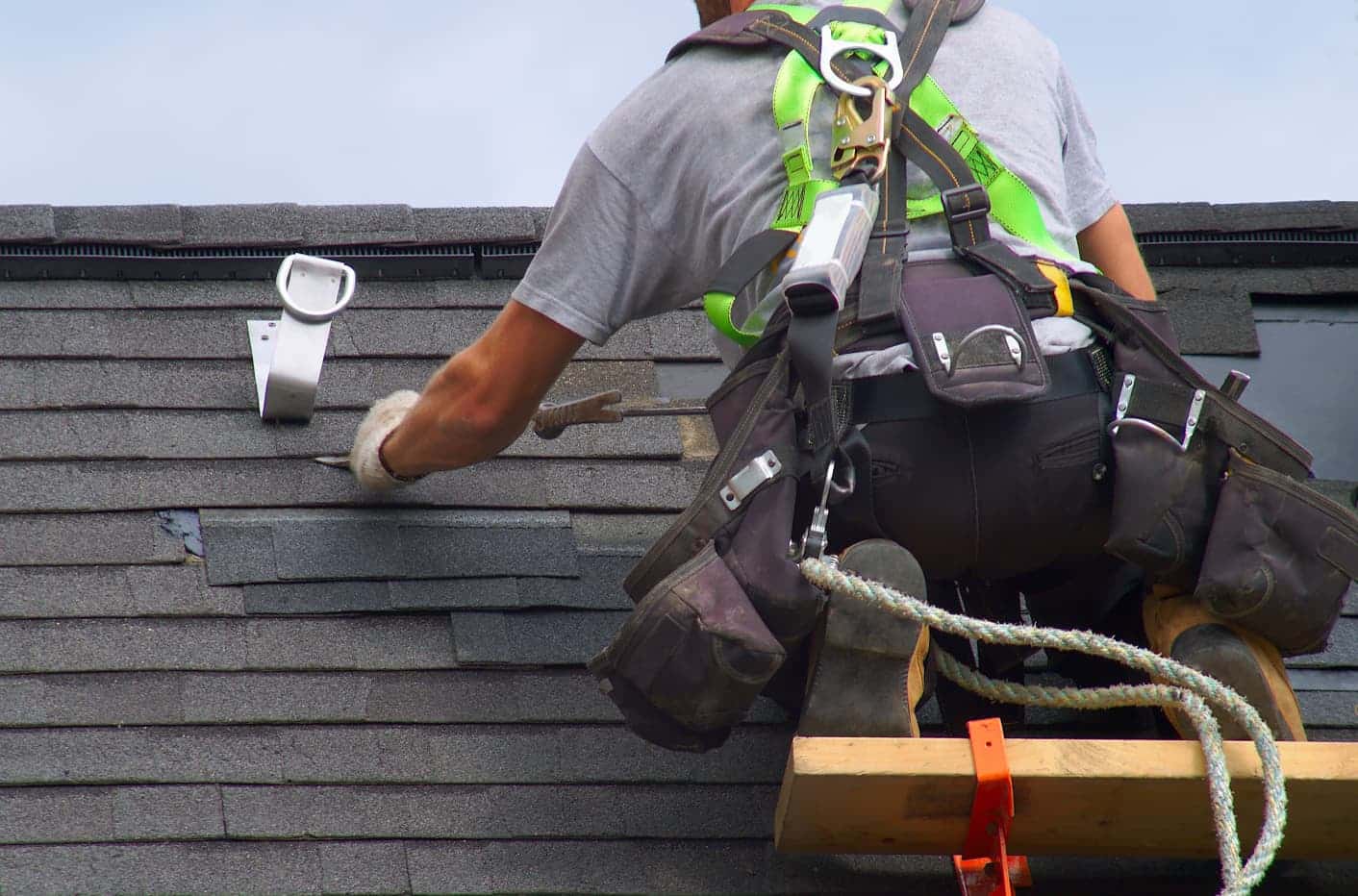 Roofer repairing shingle roof