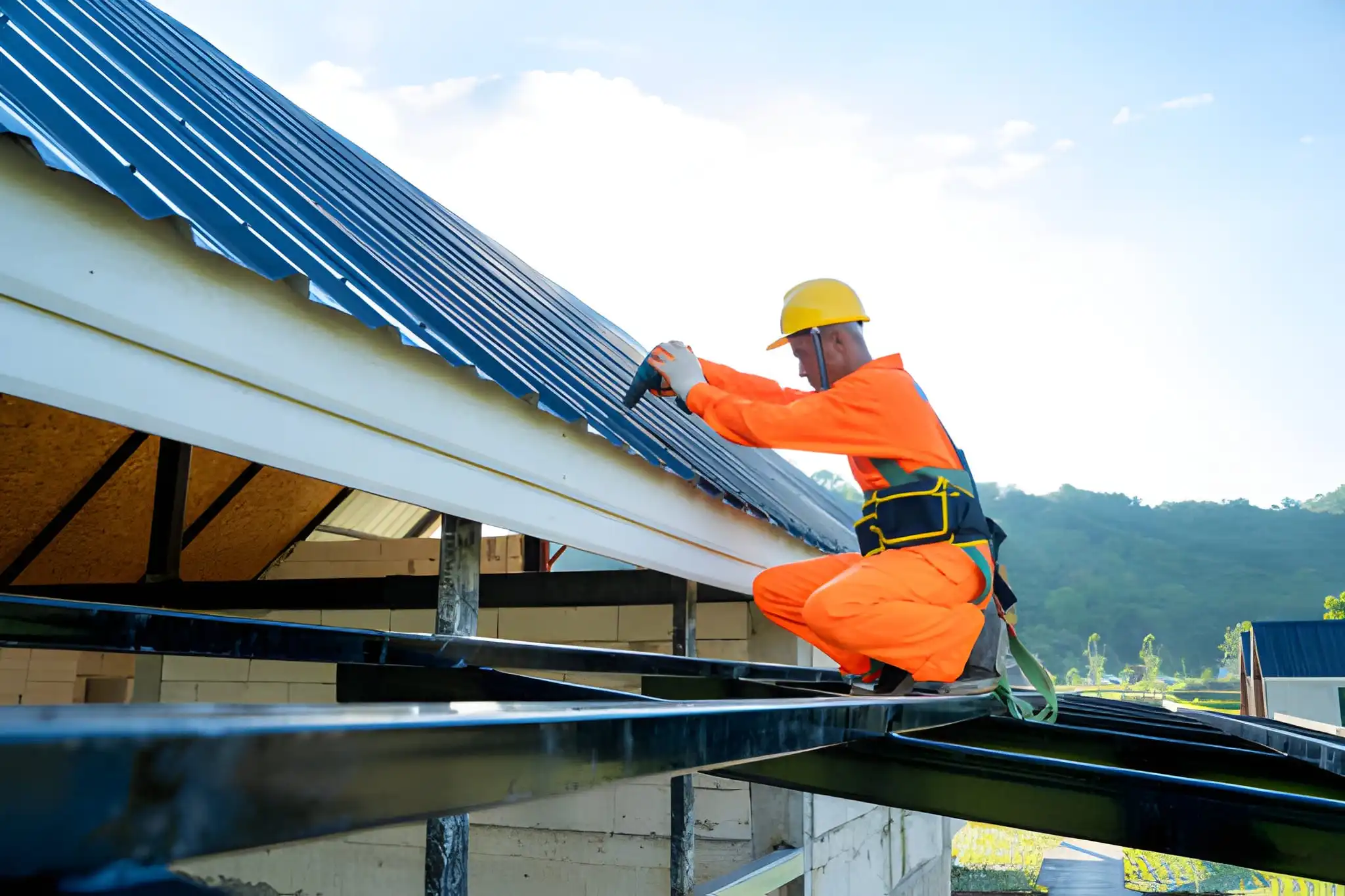 Roofer worker using air or pneumatic nail gun and installing asphalt shingle